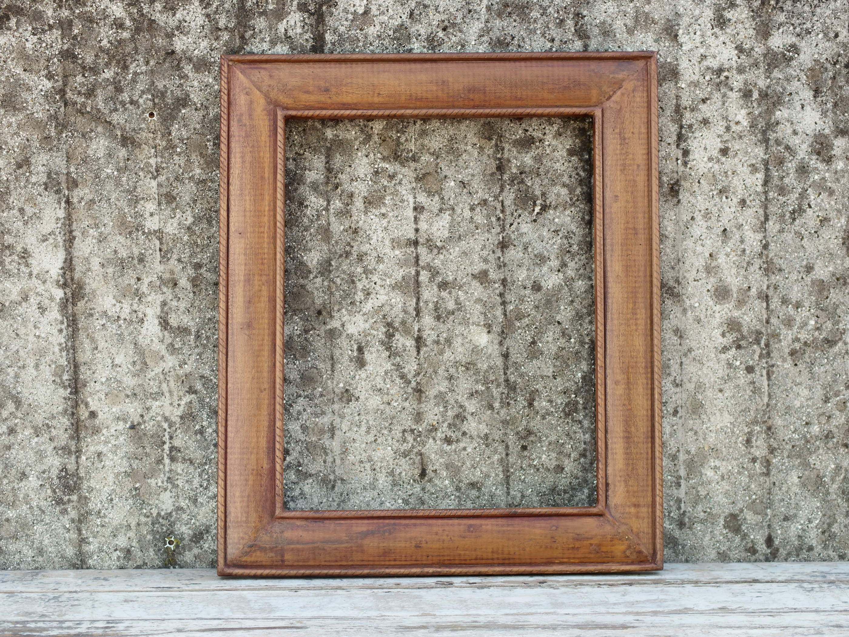 Cornice in legno di teak leggermente decorata sui bordi.  Dimensioni 60x71 prof.3cm.
