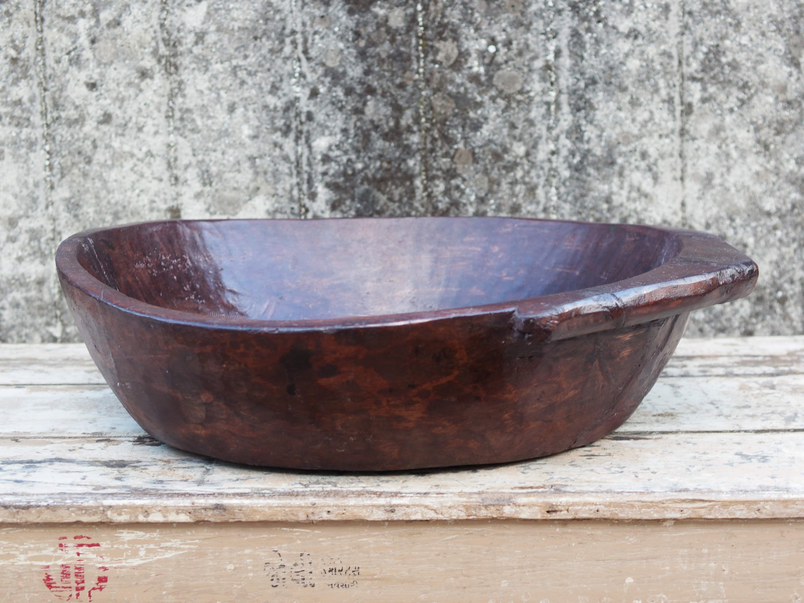 piatto in legno ricavato da un unico tronco di legno. usato in principio come piatto, setaccio per esiccare i cereali. tronco unico di teak massello databile inizio / metà 900.  dimensioni 57x53 h14cm.
