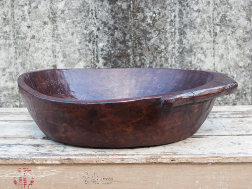 piatto in legno ricavato da un unico tronco di legno. usato in principio come piatto, setaccio per esiccare i cereali. tronco unico di teak massello databile inizio / metà 900.  dimensioni 57x53 h14cm.