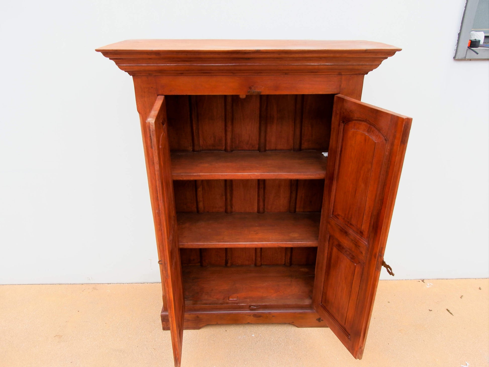 mobile coloniale indiano autentico costruito artigianalmente in legno di teak massello .  pezzo unico databile primi 900 , conservato perfettamente , non necessita di restauro .  misure 100 x 41 h137 cm  2 mensole all'interno ( si possono , su richiesta , togliere o aggiungerne altre )  fianchi lavorati stondati , idem per cornice ed ante .