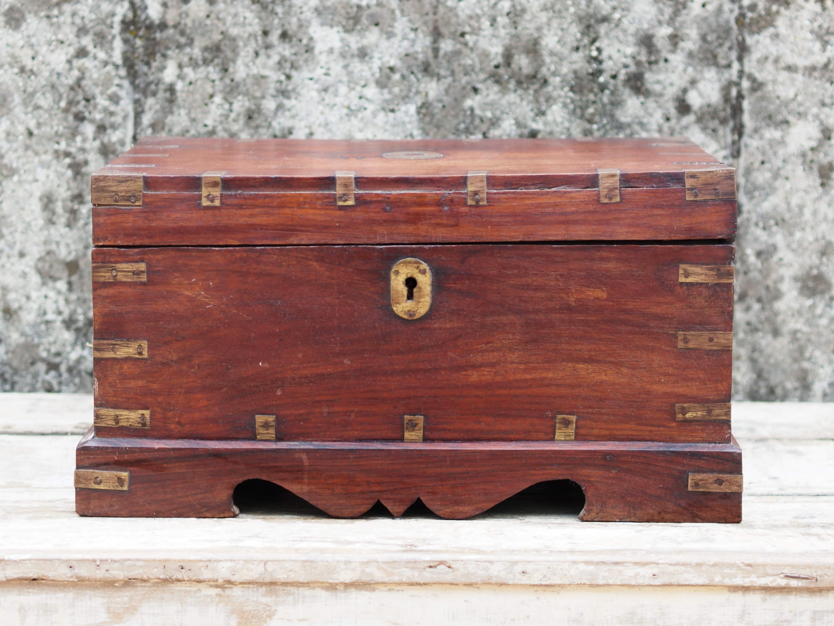 Piccolo baule Indiano in legno di rosa e teak, lavorato all'interno con piccoli scomparti e cassettini. Venivano usate in genere dagli Inglesi per i continui spostamenti per contenere spezie, trucco e gioielli di uso giornaliero. Pezzo interamente originale e perfettamente integro, di difficile reperibilità.  Dimensioni 44x31xh23cm.