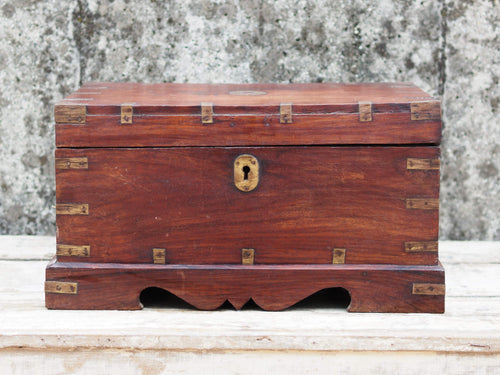 Piccolo baule Indiano in legno di rosa e teak, lavorato all'interno con piccoli scomparti e cassettini. Venivano usate in genere dagli Inglesi per i continui spostamenti per contenere spezie, trucco e gioielli di uso giornaliero. Pezzo interamente originale e perfettamente integro, di difficile reperibilità.  Dimensioni 44x31xh23cm.