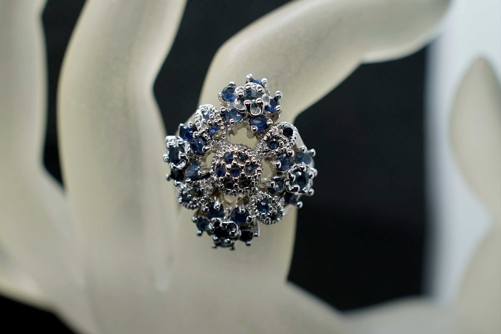 Primo piano del medaglione floreale 25x25 mm con zaffiri blu incastonati a grappolo dell'anello