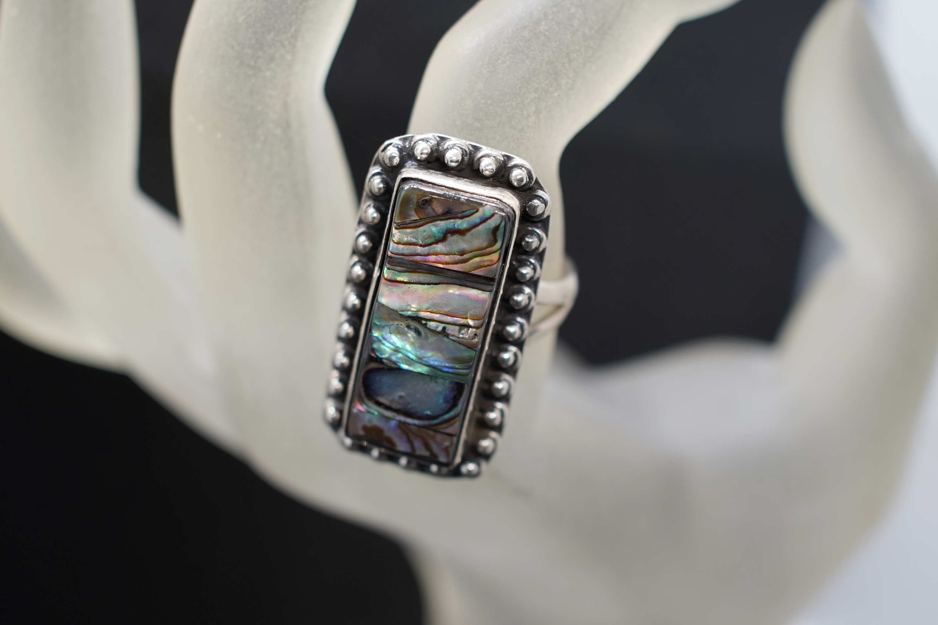 Primo piano della lavorazione a micro-sfere in argento brunito dell'anello rettangolare Abalone