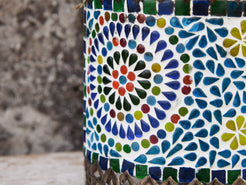 Particolare della decorazione a mosaico in vetro colorato che compongono i rosoni floreali.