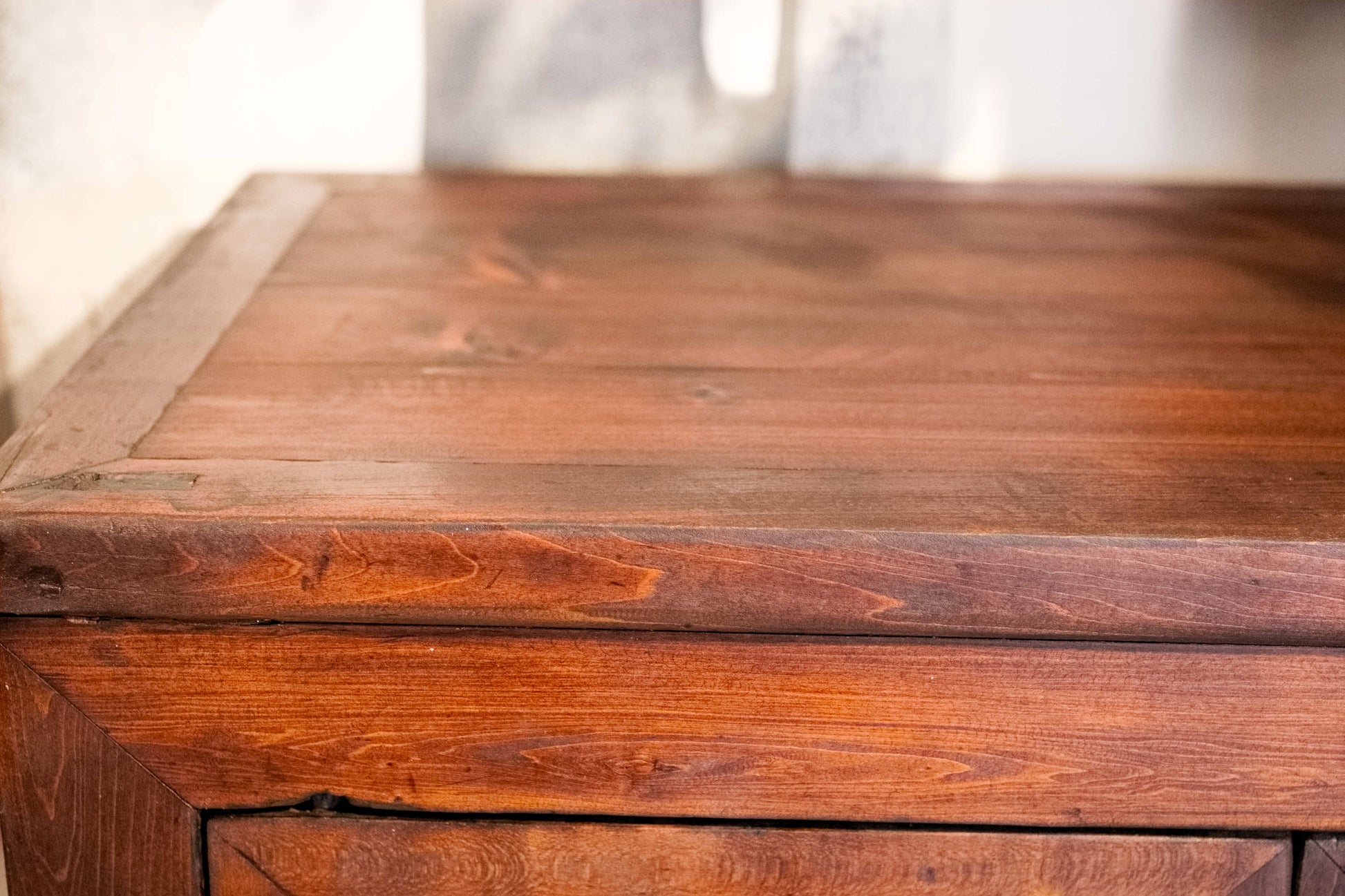 Primo piano della venatura fiammata dell'olmo portata a legno naturale grazie al restauro conservativo 