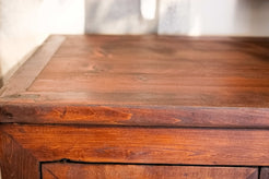 Primo piano della venatura fiammata dell'olmo portata a legno naturale grazie al restauro conservativo 