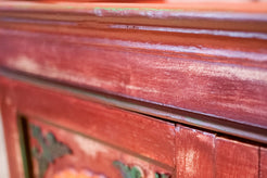Particolare delle sfumature cromatiche e della finitura artigianale applicata sulla superficie in legno di teak.