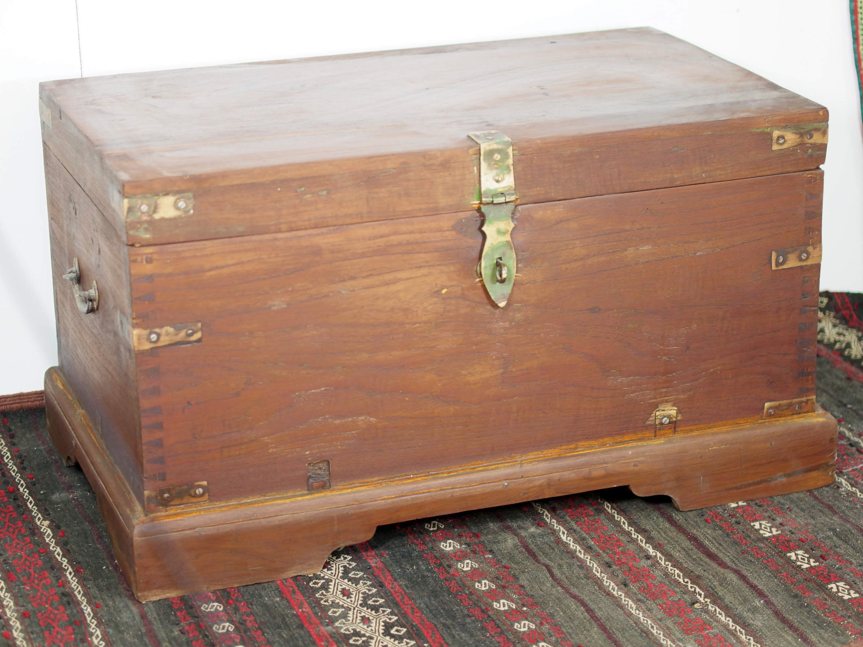 Baule Indiano in legno di teak con rinforzi laterali in ottone. Venivano usate in genere dagli Inglesi per i comuni spostamenti per contenere spezie, trucco e gioielli di uso giornaliero. Pezzo interamente originale e di difficile reperibilità. Databile primi '900.  Dimensioni 82x47 h46cm