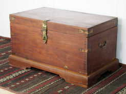 Baule Indiano in legno di teak con rinforzi laterali in ottone. Venivano usate in genere dagli Inglesi per i comuni spostamenti per contenere spezie, trucco e gioielli di uso giornaliero. Pezzo interamente originale e di difficile reperibilità. Databile primi '900.  Dimensioni 82x47 h46cm