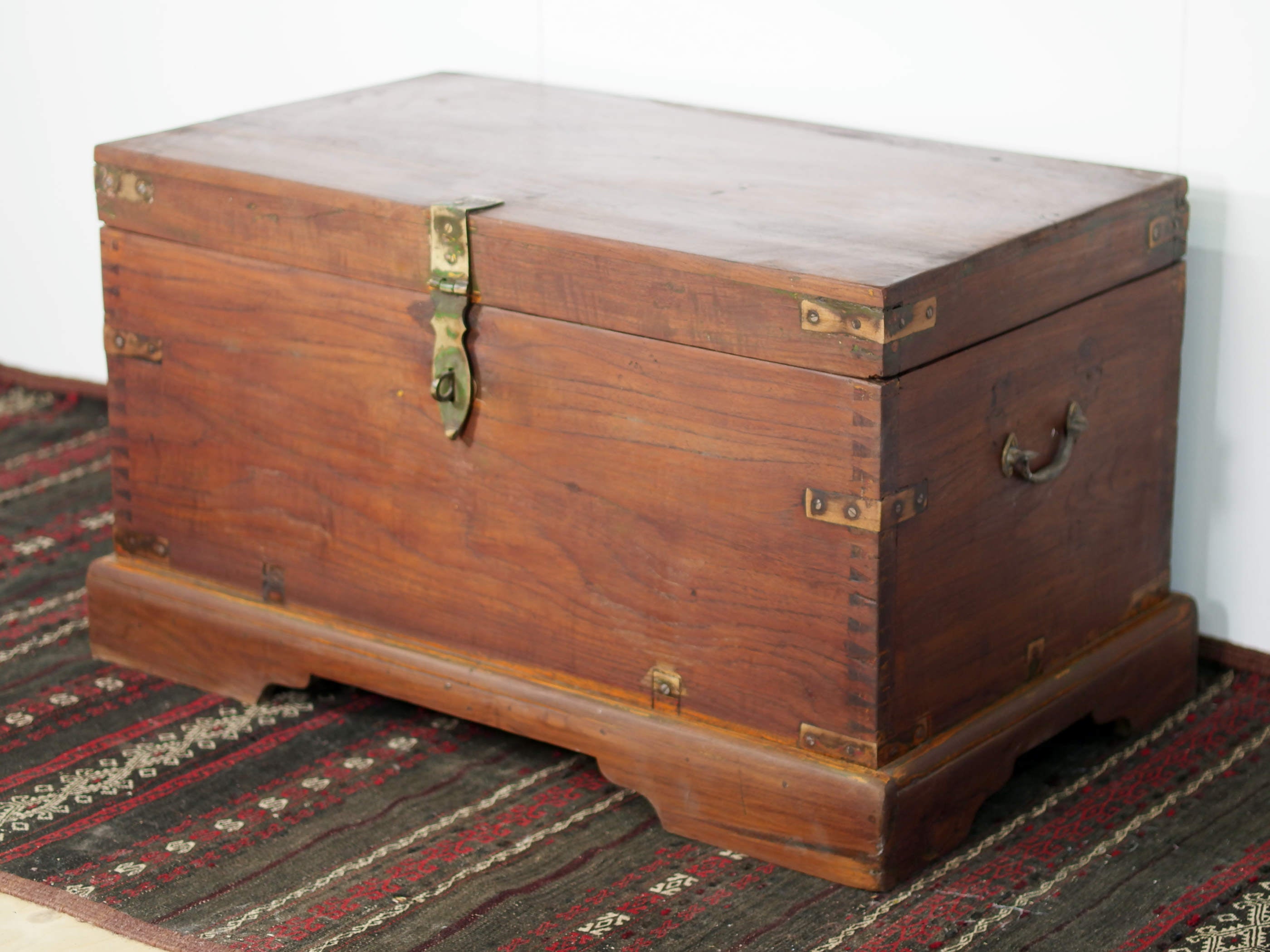 Baule Indiano in legno di teak con rinforzi laterali in ottone. Venivano usate in genere dagli Inglesi per i comuni spostamenti per contenere spezie, trucco e gioielli di uso giornaliero. Pezzo interamente originale e di difficile reperibilità. Databile primi '900.  Dimensioni 82x47 h46cm
