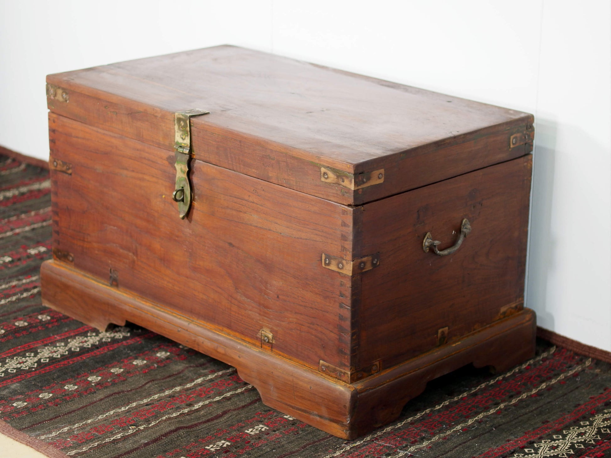 Baule Indiano in legno di teak con rinforzi laterali in ottone. Venivano usate in genere dagli Inglesi per i comuni spostamenti per contenere spezie, trucco e gioielli di uso giornaliero. Pezzo interamente originale e di difficile reperibilità. Databile primi '900.  Dimensioni 82x47 h46cm