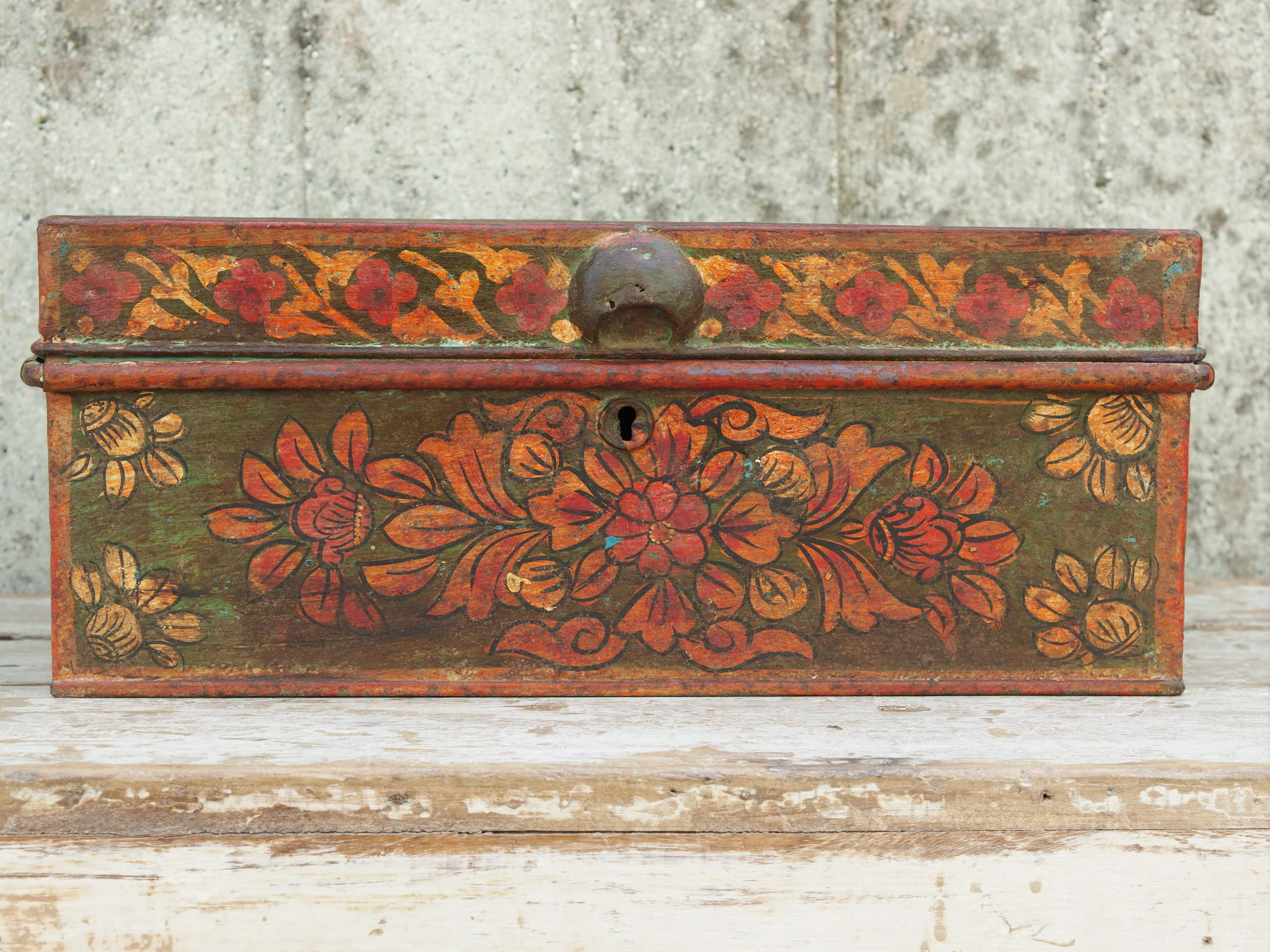 vecchio box, bauletto, scatola, indiana in metallo dipinto con motivi floreali. impiegata solitamente per le offerte nei templi o come cassa nei negozi, motivo per cui sopra vi è un foro dove mettere le offerte. internamente sono presenti vari scomparti. assemblata artigianalmente, originale in ogni parte. pezzo vintage, anno '50/60 pezzo unico.  dimensioni 42x29 h17 cm