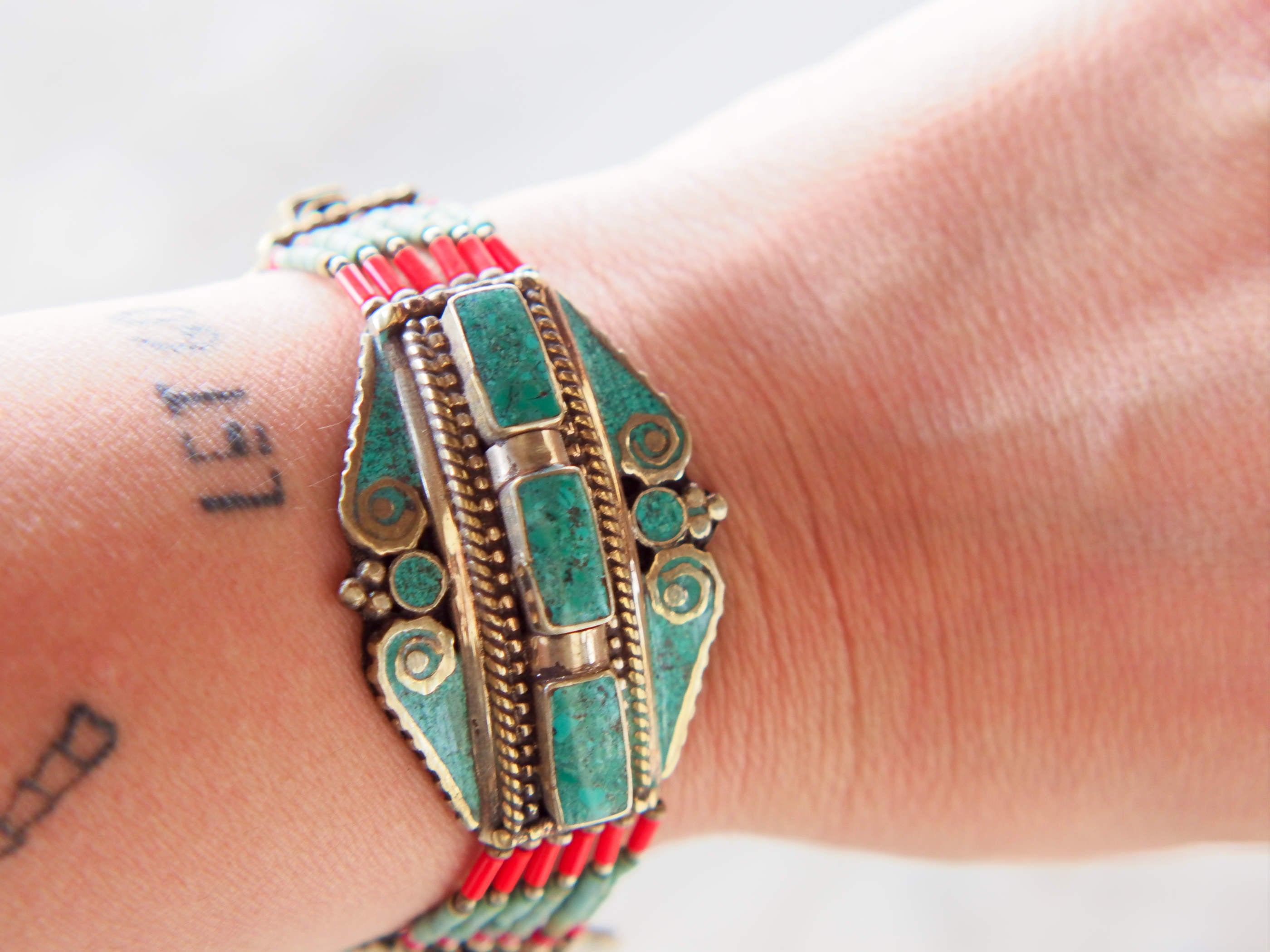 bracciale nepalese, tibetano in argento e pietre semipreziose, turchese e corallo, chiusura a scorrimento. lavorato a mano pezzo unico tribale.  altezza bracciale 3cm, lunghezza minima 22, massima 27, peso 43 gr 