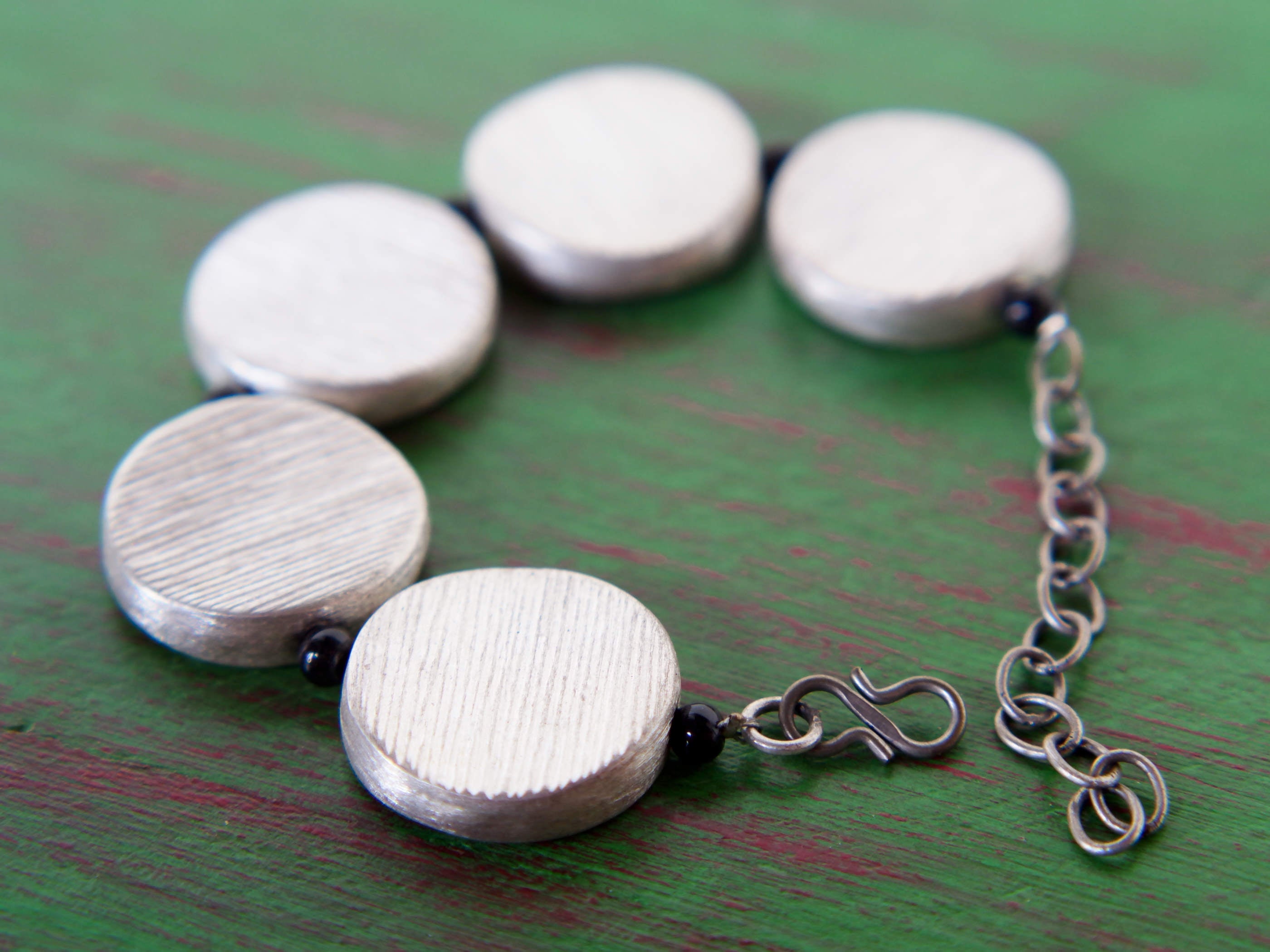 bracciale in argento 925 e onice, lavorato artigianalmente, pezzo unico. larghezza 2.5cm, lunghezza regolabile da un minimo di 17cm fino a un massimo di 22cm, peso 43 gr