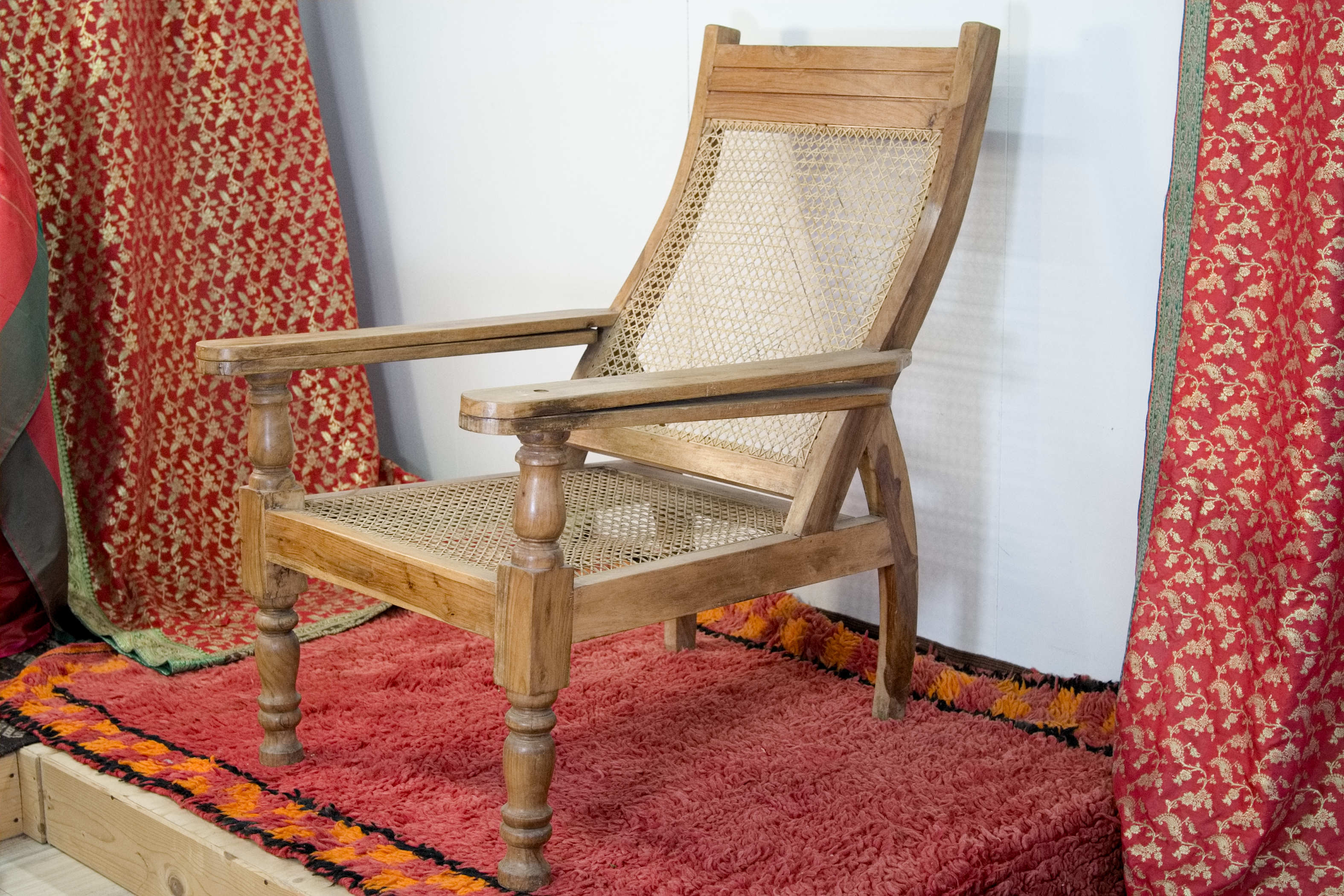 Vista d'insieme della chaise longue coloniale in legno di teak con paglia di Vienna.