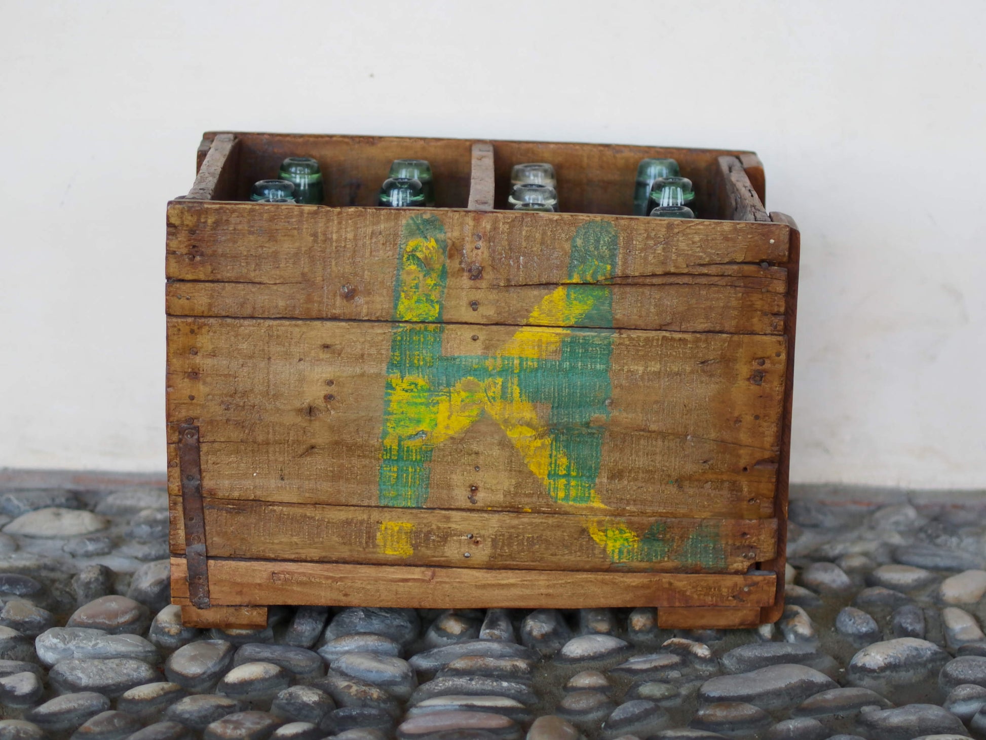 Cassa in legno con 12 bottiglie per acqua frizzante. In uso in India dagli anni 40 ai primi anni 90 le bottiglie venovano usate per fare l'acqua frizzante. Bottiglie e cassetta interamente lavorate in modo artigianale, pezzo vintage originale e di difficile reperibilità se completo come l'articolo in foto. Ogni bottiglia è differente l'una dall'altra ed ogni cassa ha delle caratteristiche relative a fornitore, regione...  dimensioni 30x30xh40cm