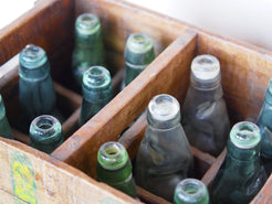 Cassa in legno con 12 bottiglie per acqua frizzante. In uso in India dagli anni 40 ai primi anni 90 le bottiglie venovano usate per fare l'acqua frizzante. Bottiglie e cassetta interamente lavorate in modo artigianale, pezzo vintage originale e di difficile reperibilità se completo come l'articolo in foto. Ogni bottiglia è differente l'una dall'altra ed ogni cassa ha delle caratteristiche relative a fornitore, regione...  dimensioni 30x30xh40cm