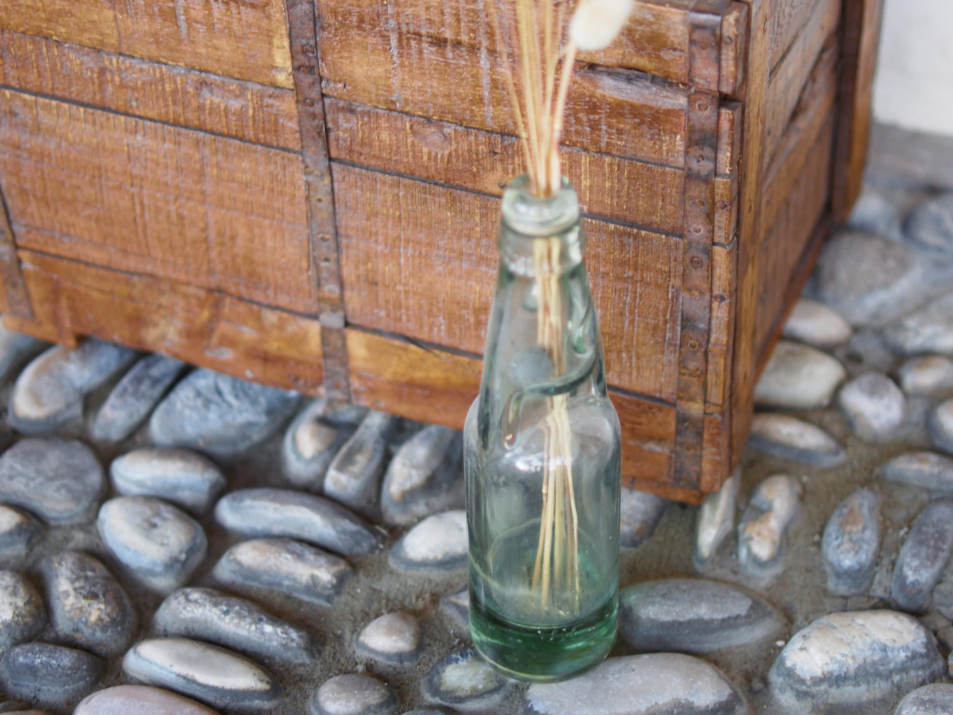 Cassa in legno con 12 bottiglie per acqua frizzante. In uso in India dagli anni 40 ai primi anni 90 le bottiglie venovano usate per fare l'acqua frizzante. Bottiglie e cassetta interamente lavorate in modo artigianale, pezzo vintage originale e di difficile reperibilità se completo come l'articolo in foto. Ogni bottiglia è differente l'una dall'altra ed ogni cassa ha delle caratteristiche relative a fornitore, regione...  dimensioni 30x30xh40cm