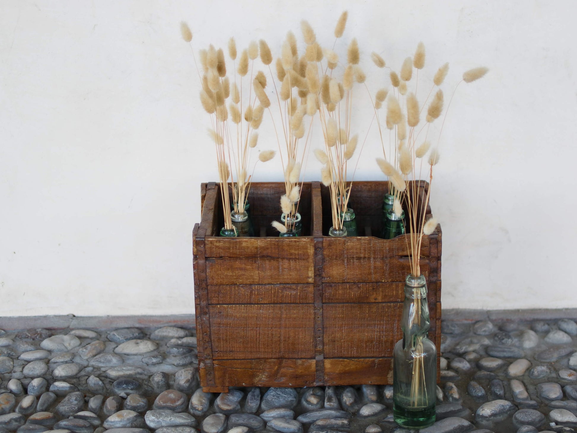 Cassa in legno con 12 bottiglie per acqua frizzante. In uso in India dagli anni 40 ai primi anni 90 le bottiglie venovano usate per fare l'acqua frizzante. Bottiglie e cassetta interamente lavorate in modo artigianale, pezzo vintage originale e di difficile reperibilità se completo come l'articolo in foto. Ogni bottiglia è differente l'una dall'altra ed ogni cassa ha delle caratteristiche relative a fornitore, regione...  dimensioni 30x30xh40cm
