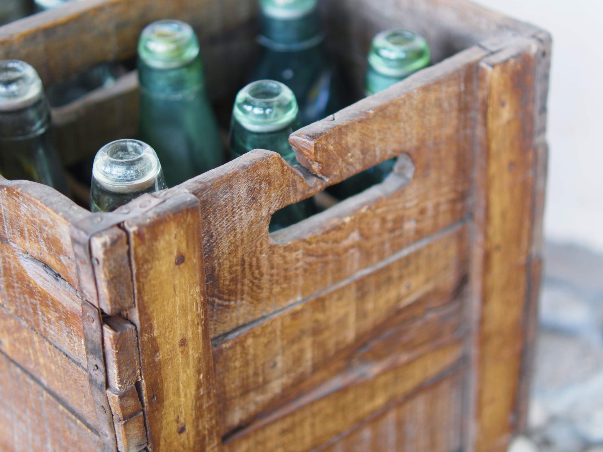 Cassa in legno con 12 bottiglie per acqua frizzante. In uso in India dagli anni 40 ai primi anni 90 le bottiglie venovano usate per fare l'acqua frizzante. Bottiglie e cassetta interamente lavorate in modo artigianale, pezzo vintage originale e di difficile reperibilità se completo come l'articolo in foto. Ogni bottiglia è differente l'una dall'altra ed ogni cassa ha delle caratteristiche relative a fornitore, regione...  dimensioni 30x30xh40cm