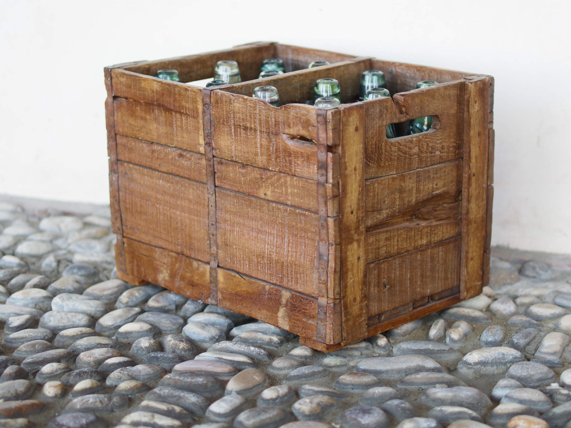 Cassa in legno con 12 bottiglie per acqua frizzante. In uso in India dagli anni 40 ai primi anni 90 le bottiglie venovano usate per fare l'acqua frizzante. Bottiglie e cassetta interamente lavorate in modo artigianale, pezzo vintage originale e di difficile reperibilità se completo come l'articolo in foto. Ogni bottiglia è differente l'una dall'altra ed ogni cassa ha delle caratteristiche relative a fornitore, regione...  dimensioni 30x30xh40cm