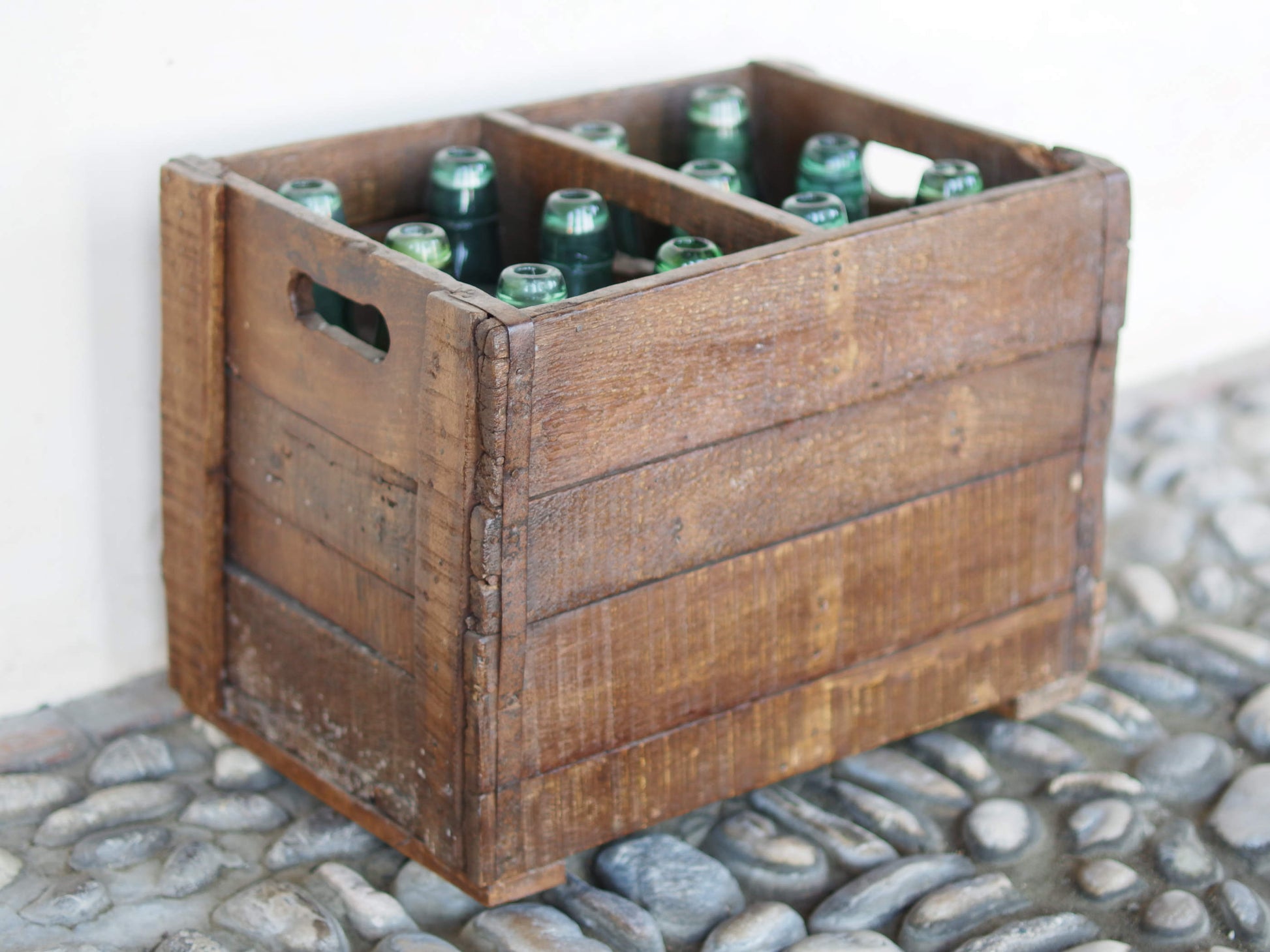 Cassa in legno con 12 bottiglie per acqua frizzante. In uso in India dagli anni 40 ai primi anni 90 le bottiglie venovano usate per fare l'acqua frizzante. Bottiglie e cassetta interamente lavorate in modo artigianale, pezzo vintage originale e di difficile reperibilità se completo come l'articolo in foto. Ogni bottiglia è differente l'una dall'altra ed ogni cassa ha delle caratteristiche relative a fornitore, regione...  dimensioni 30x30xh40cm