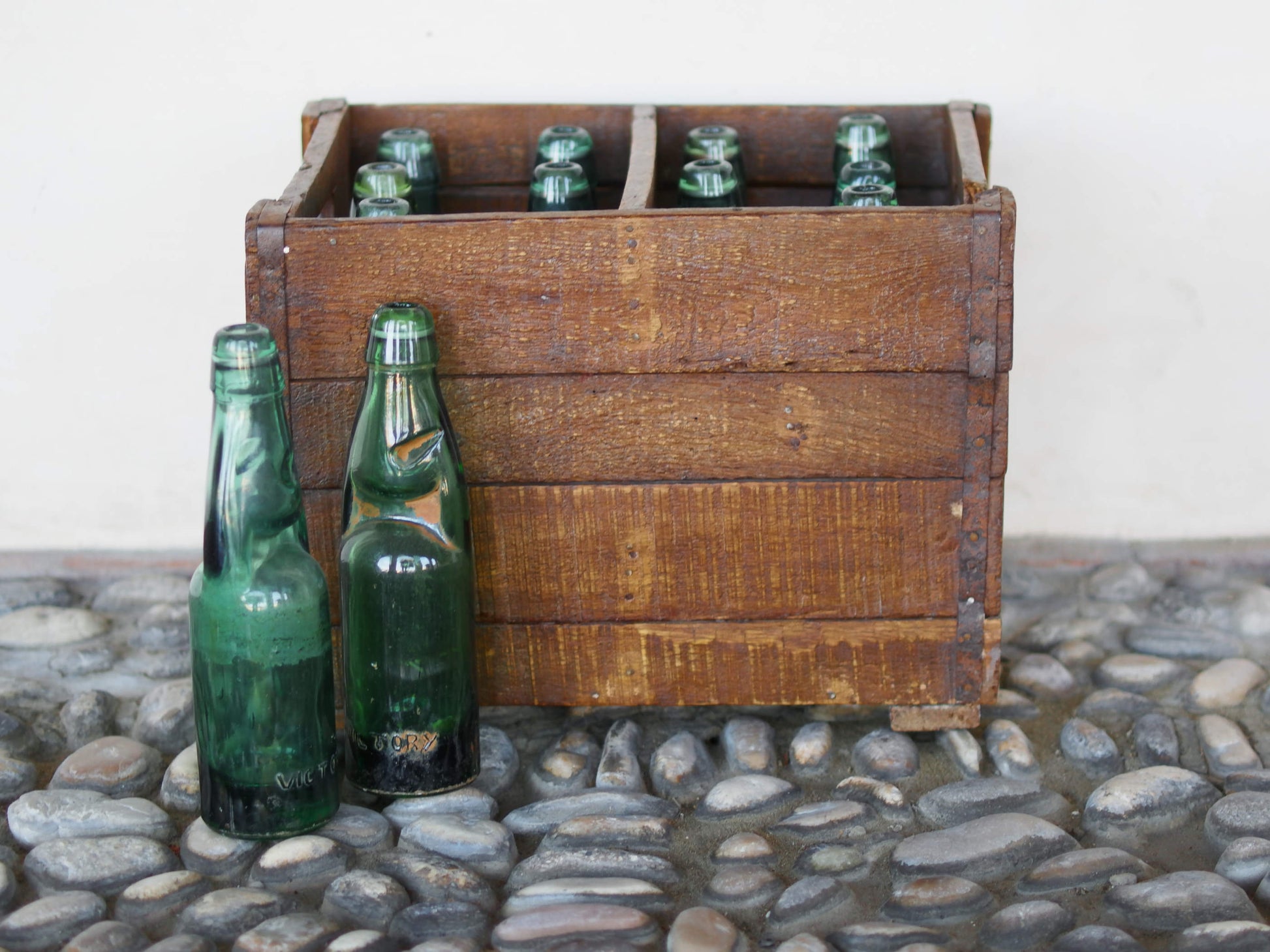 Cassa in legno con 12 bottiglie per acqua frizzante. In uso in India dagli anni 40 ai primi anni 90 le bottiglie venovano usate per fare l'acqua frizzante. Bottiglie e cassetta interamente lavorate in modo artigianale, pezzo vintage originale e di difficile reperibilità se completo come l'articolo in foto. Ogni bottiglia è differente l'una dall'altra ed ogni cassa ha delle caratteristiche relative a fornitore, regione...  dimensioni 30x30xh40cm