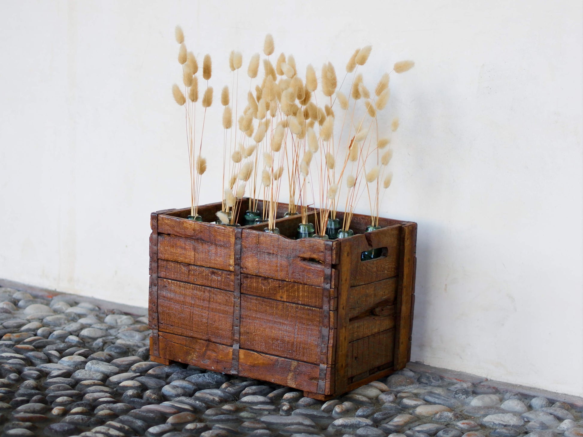 Cassa in legno con 12 bottiglie per acqua frizzante. In uso in India dagli anni 40 ai primi anni 90 le bottiglie venovano usate per fare l'acqua frizzante. Bottiglie e cassetta interamente lavorate in modo artigianale, pezzo vintage originale e di difficile reperibilità se completo come l'articolo in foto. Ogni bottiglia è differente l'una dall'altra ed ogni cassa ha delle caratteristiche relative a fornitore, regione...  dimensioni 30x30xh40cm