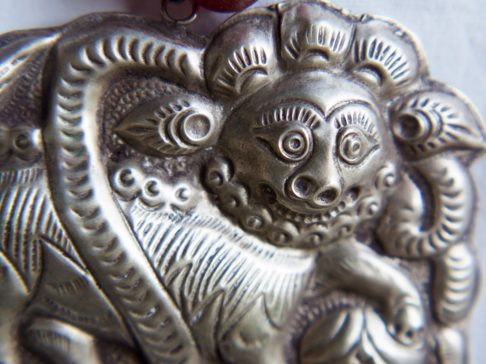 collana indiana in tessuto, pasta vitrea e lega di argento fatta a mano, sfere in pasta vitrea e nodini in cotone pendaglio con figura mitologica della cultura tibetana buddista lavorato in lega di argento  lunghezza totale ( circonferenza ) 80 cm pendaglio 9 x 7 cm escluse campane campanelle 3 cm peso 230 gr
