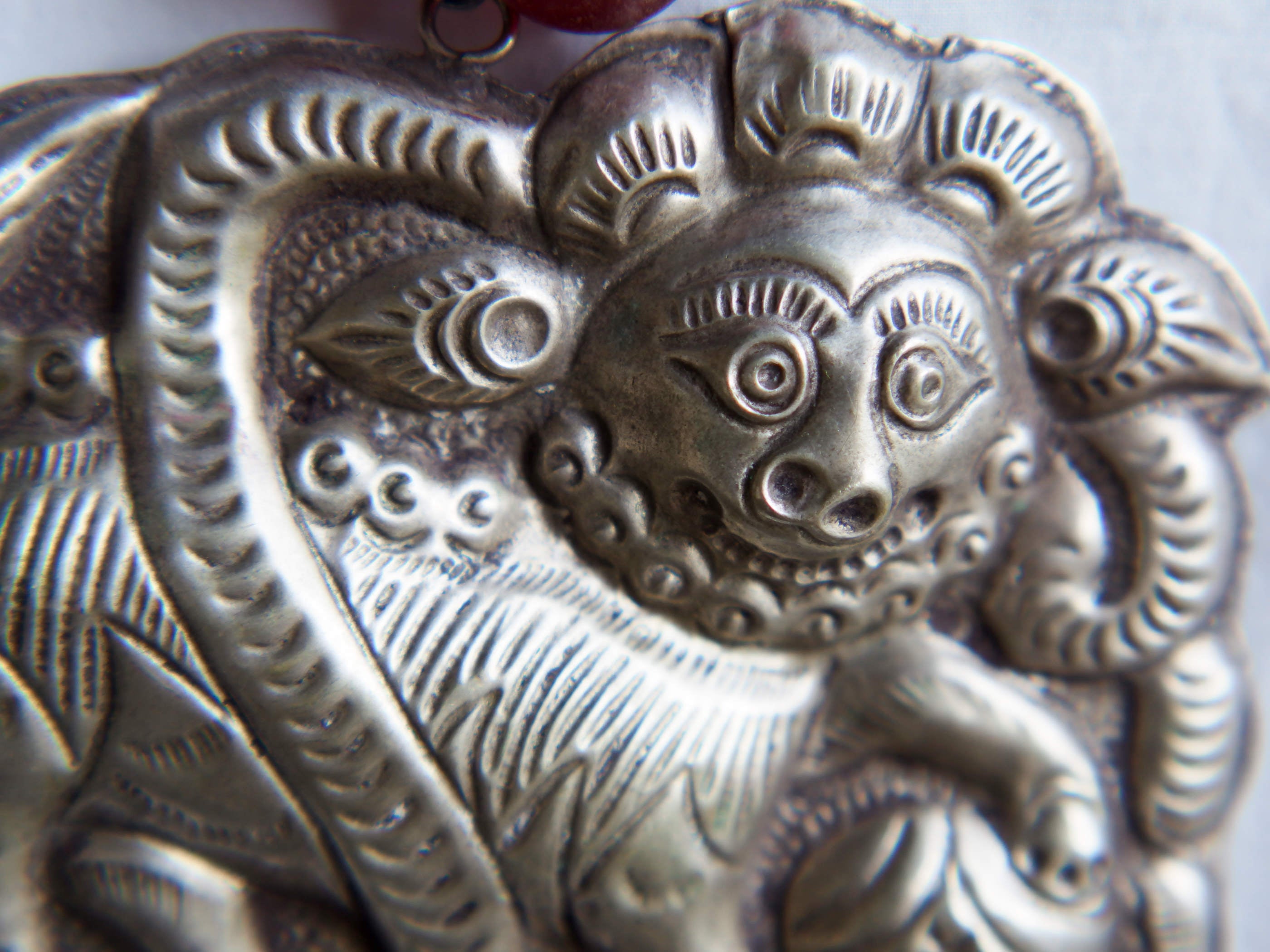 collana indiana in tessuto, pasta vitrea e lega di argento fatta a mano, sfere in pasta vitrea e nodini in cotone pendaglio con figura mitologica della cultura tibetana buddista lavorato in lega di argento  lunghezza totale ( circonferenza ) 80 cm pendaglio 9 x 7 cm escluse campane campanelle 3 cm peso 230 gr