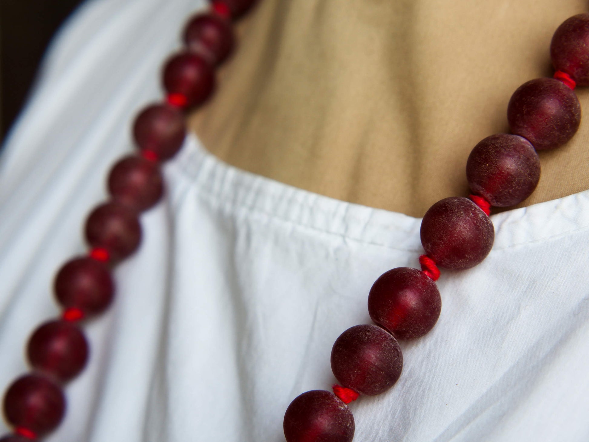 collana indiana in tessuto, pasta vitrea e lega di argento fatta a mano, sfere in pasta vitrea e nodini in cotone pendaglio con figura mitologica della cultura tibetana buddista lavorato in lega di argento  lunghezza totale ( circonferenza ) 80 cm pendaglio 9 x 7 cm escluse campane campanelle 3 cm peso 230 gr