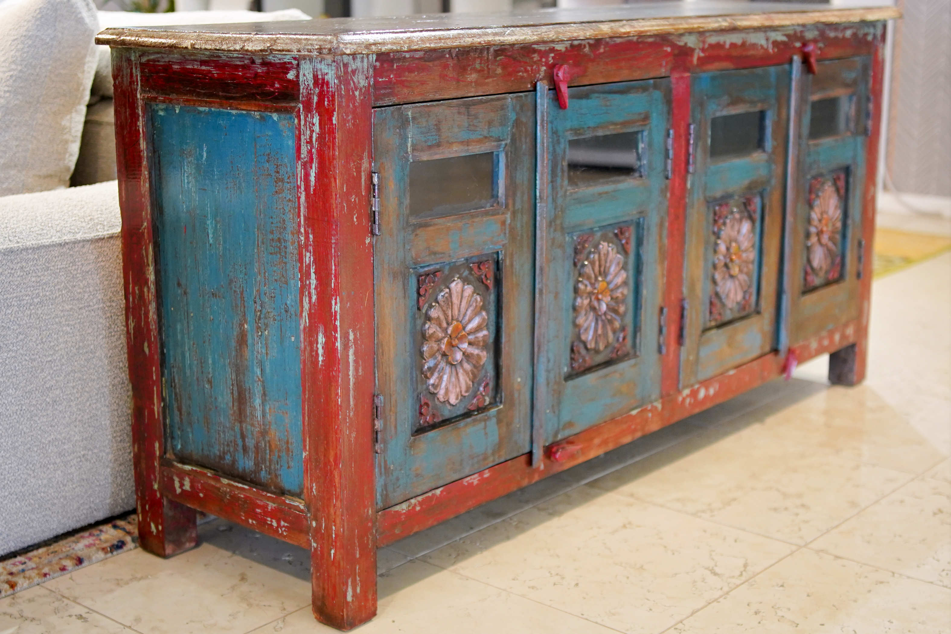 Credenza bassa indiana porta TV in legno massello di teak anni '70 con ante incise e inserti in vetro.