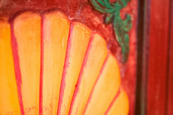 Primo piano dei dettagli decorativi a rilievo in pasta di gesso agli angoli delle ante dell'armadietto