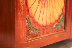 Primo piano dei dettagli decorativi a rilievo in pasta di gesso agli angoli delle ante dell'armadietto