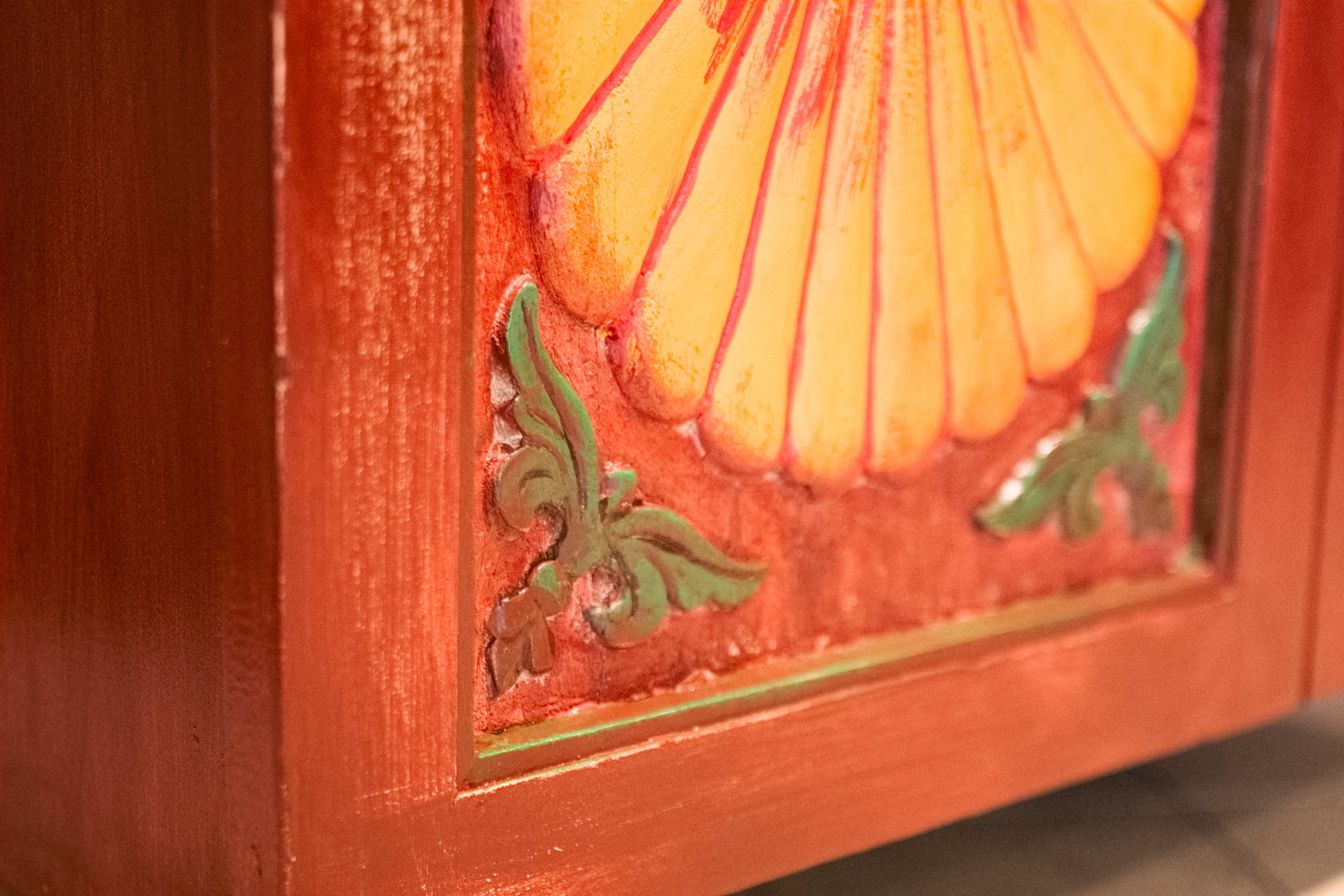 Primo piano dei dettagli decorativi a rilievo in pasta di gesso agli angoli delle ante dell'armadietto