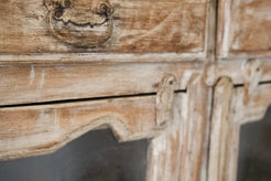 Dettaglio delle ferramenta anticate e dei pomelli ad anello applicati sui cassetti e sulle ante.