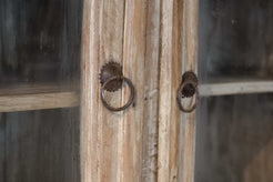 Dettaglio delle ferramenta anticate e dei pomelli ad anello applicati sui cassetti e sulle ante.
