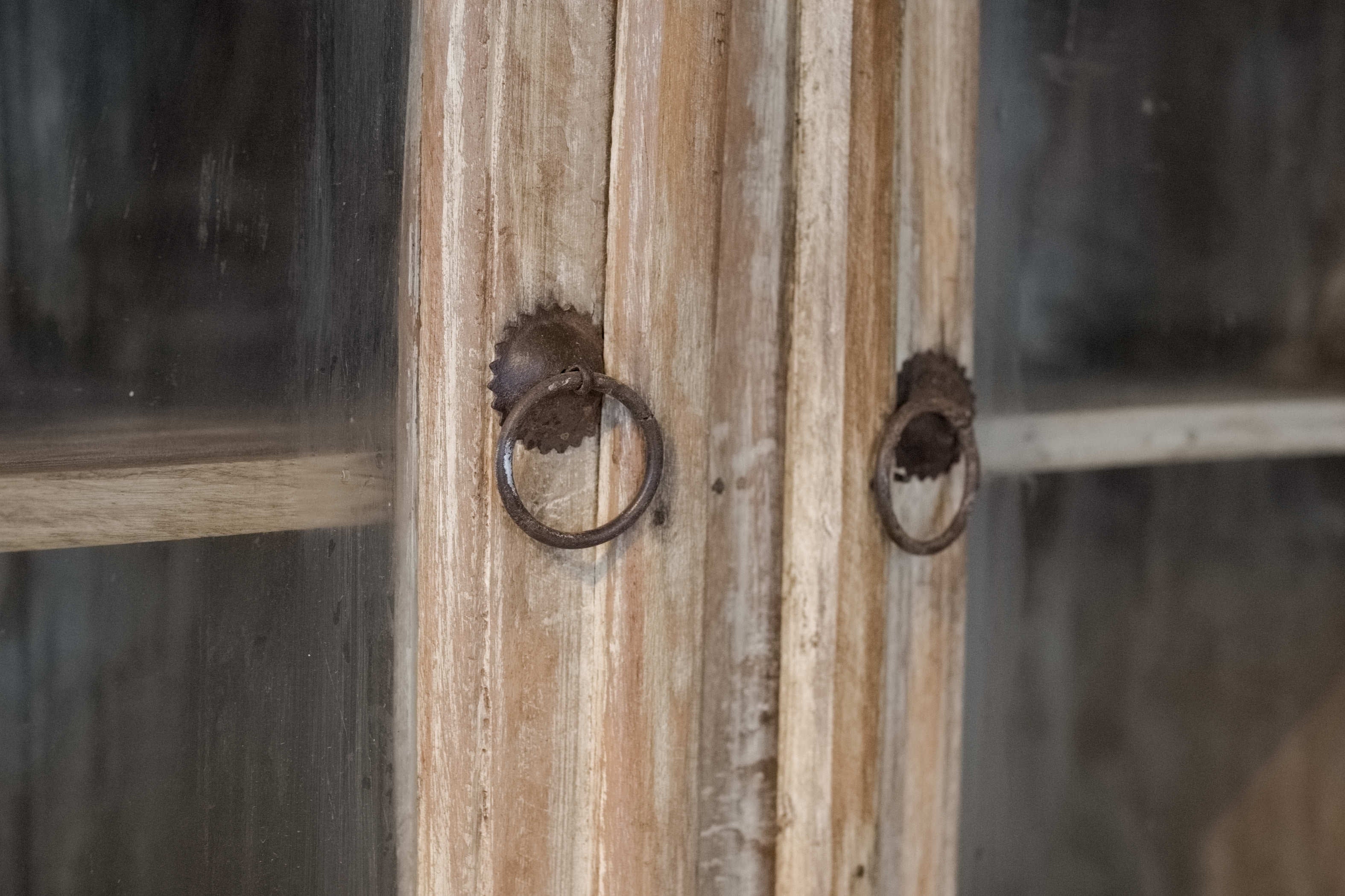 Dettaglio delle ferramenta anticate e dei pomelli ad anello applicati sui cassetti e sulle ante.