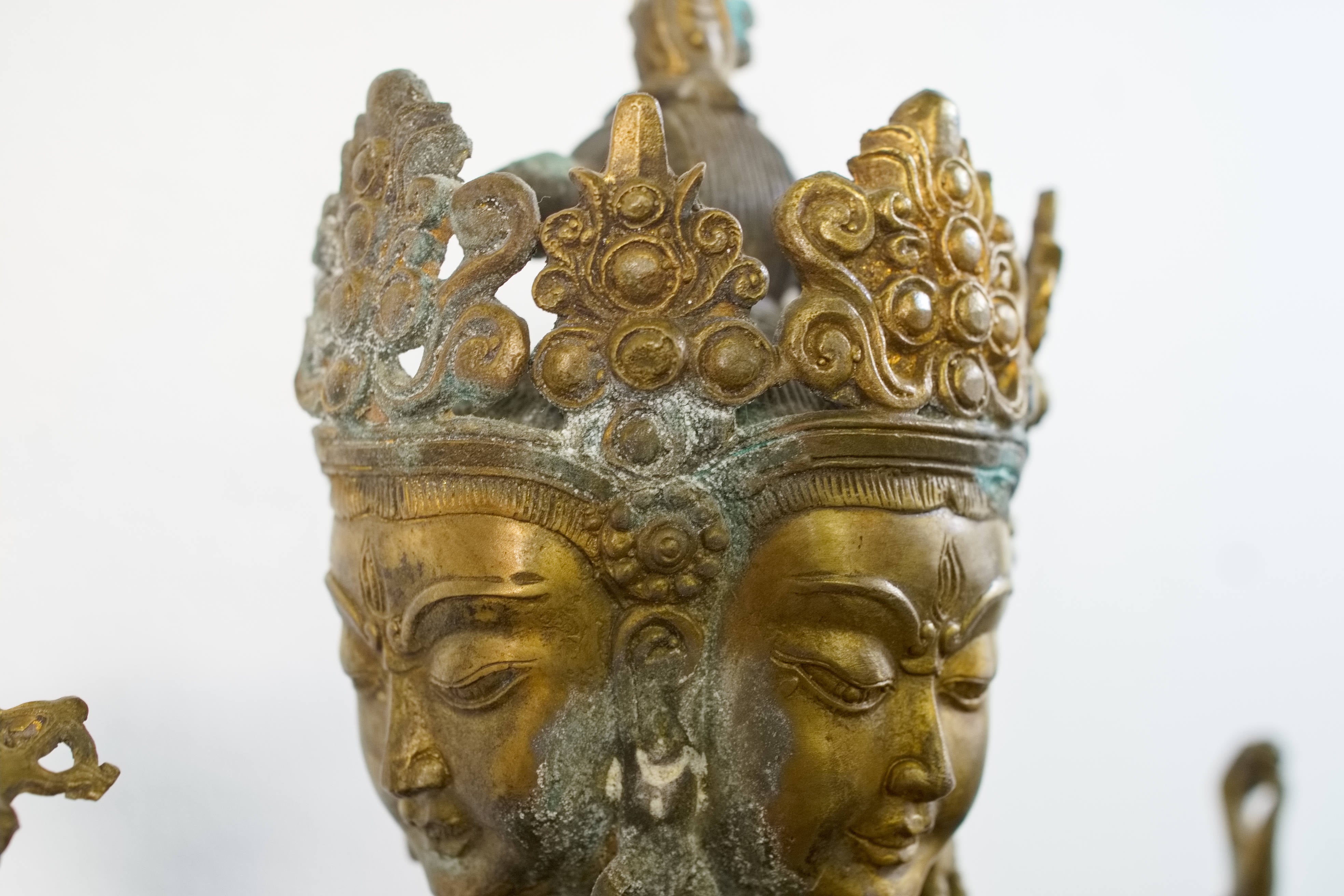 Primo piano dei tre volti e delle espressioni dettagliate della divinità tibetana.