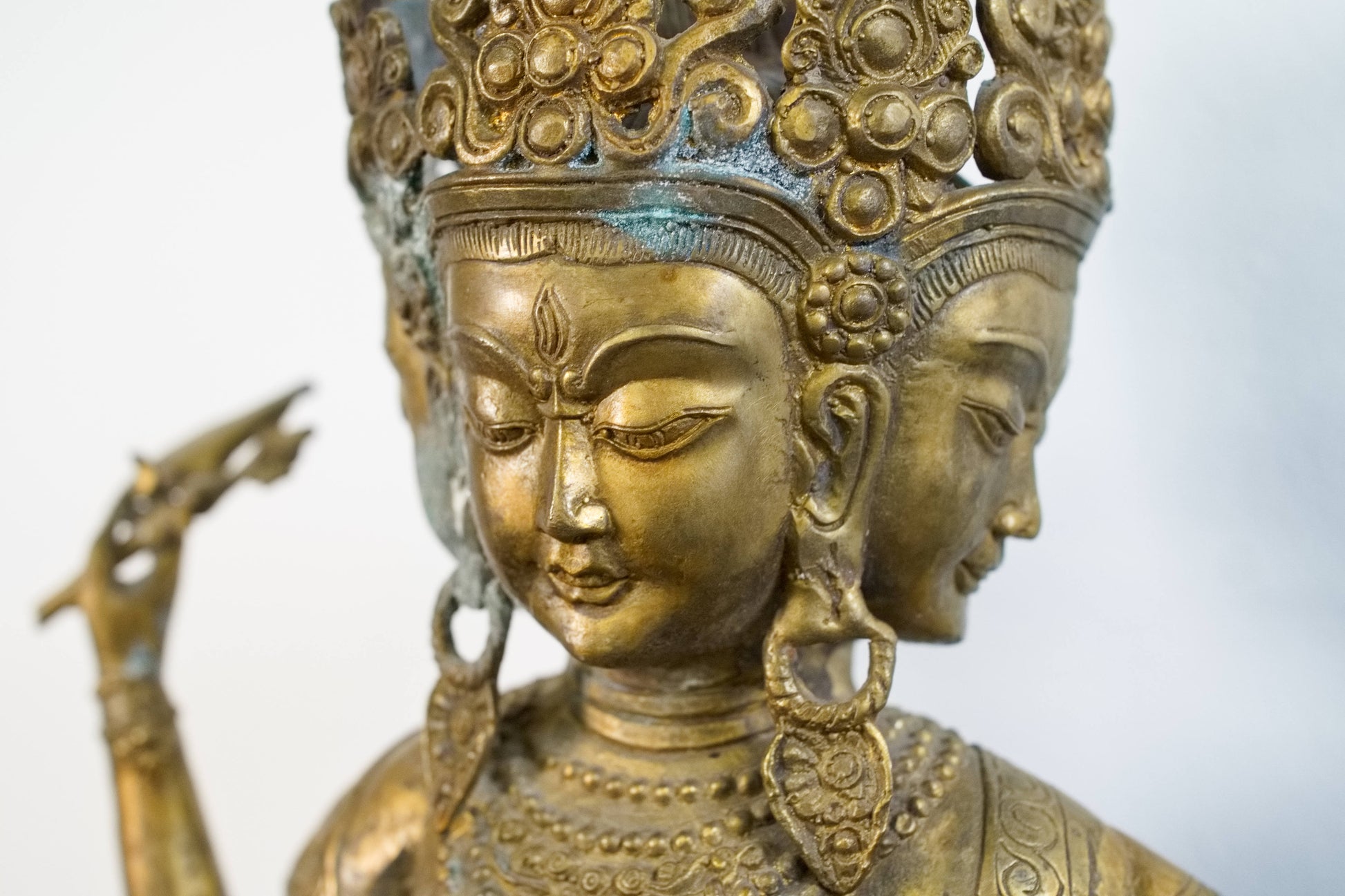Primo piano dei tre volti e delle espressioni dettagliate della divinità tibetana.