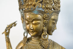 Primo piano dei tre volti e delle espressioni dettagliate della divinità tibetana.