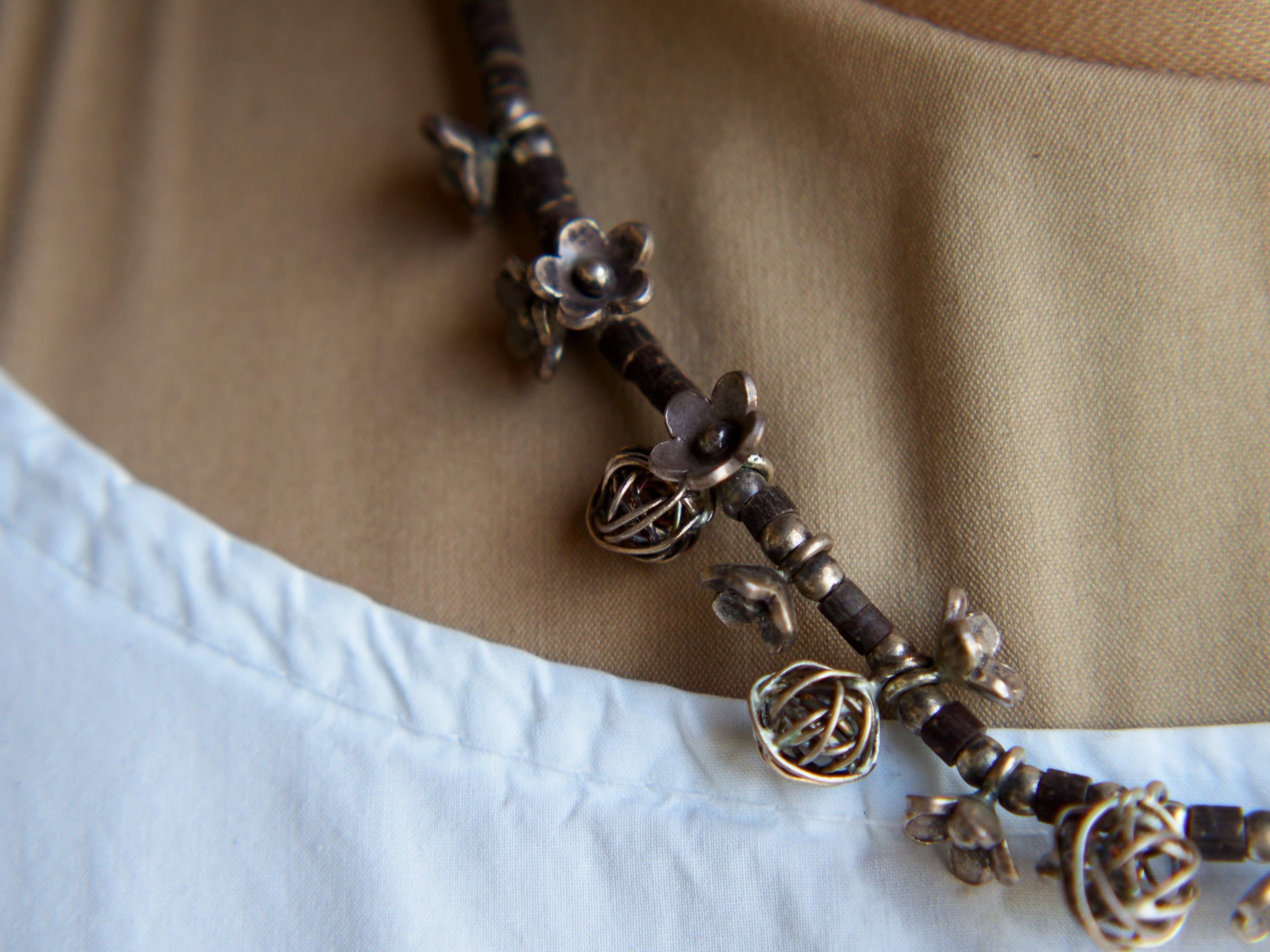 Primo piano ravvicinato della struttura in cavo d'argento e cocco di questa collana tradizionale.