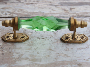 Maniglia in vetro lievemente sfaccettato di colore verde su supporto in metallo color oro. Disponibile in altri colori come da foto.  dimensioni 14x5x3cm