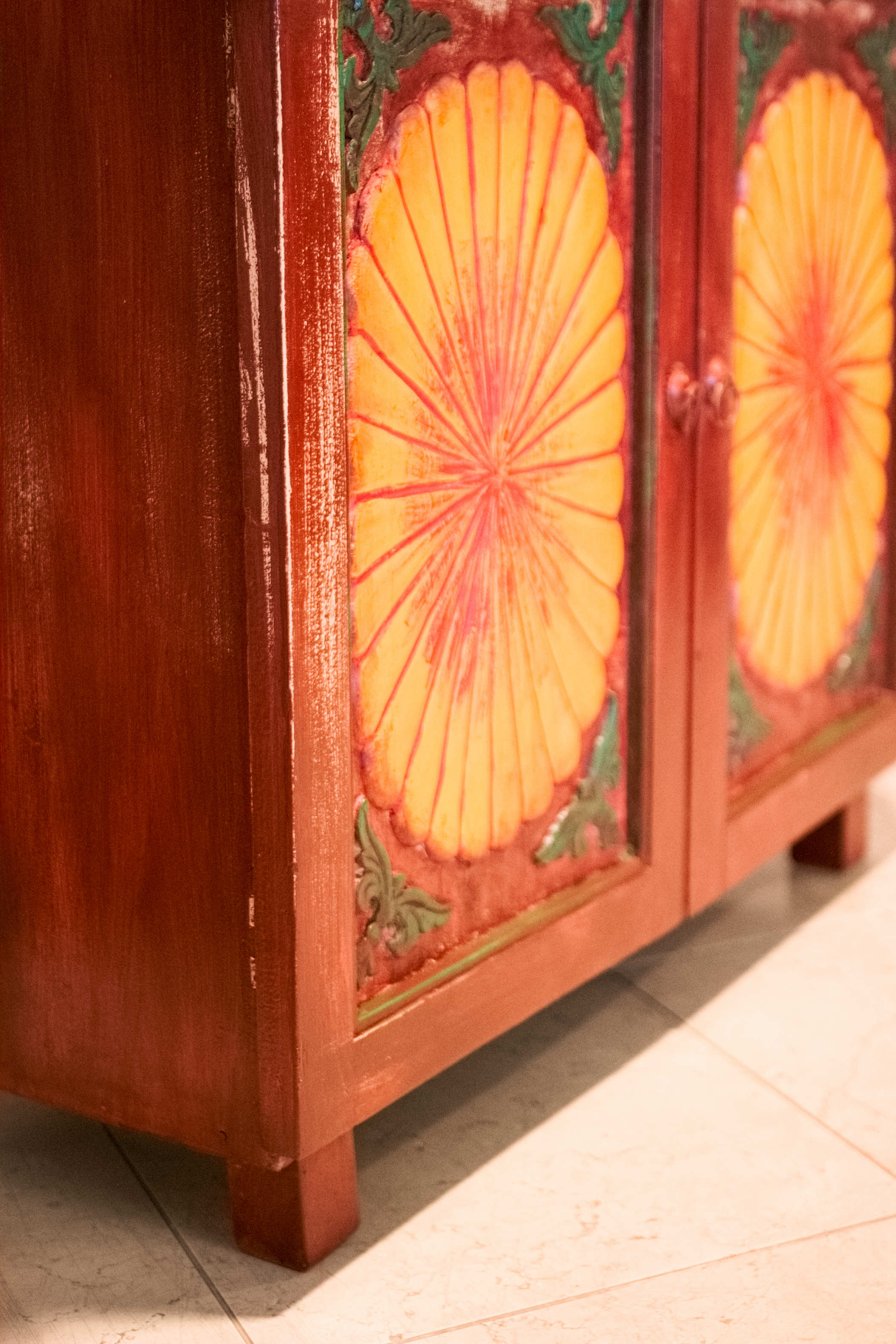 Vista laterale della credenza indiana in teak, che evidenzia la struttura solida e compatta poggiata su piedini rialzati.
