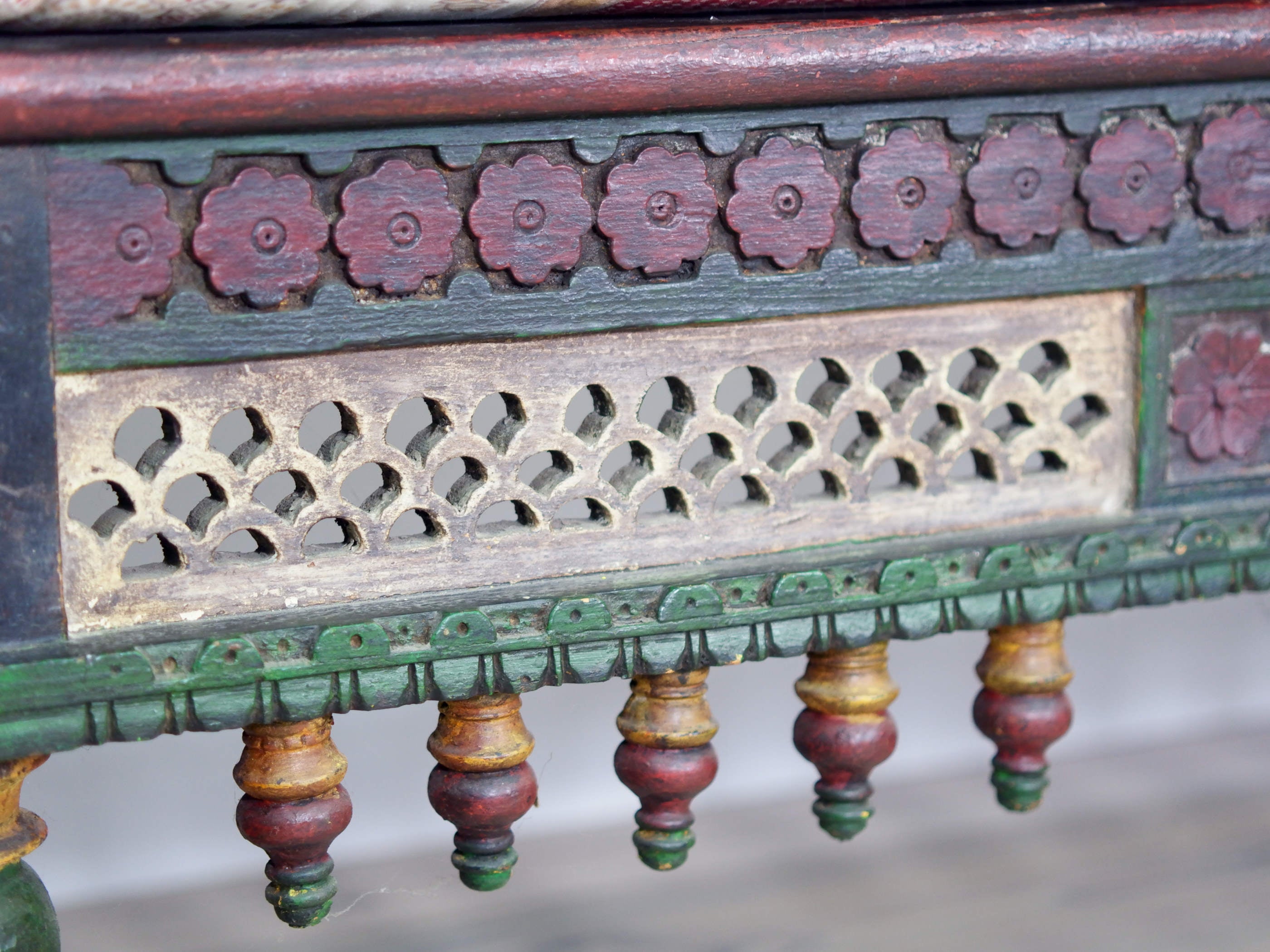 Particolare della fascia inferiore intagliata e dei pendenti decorativi pendenti.