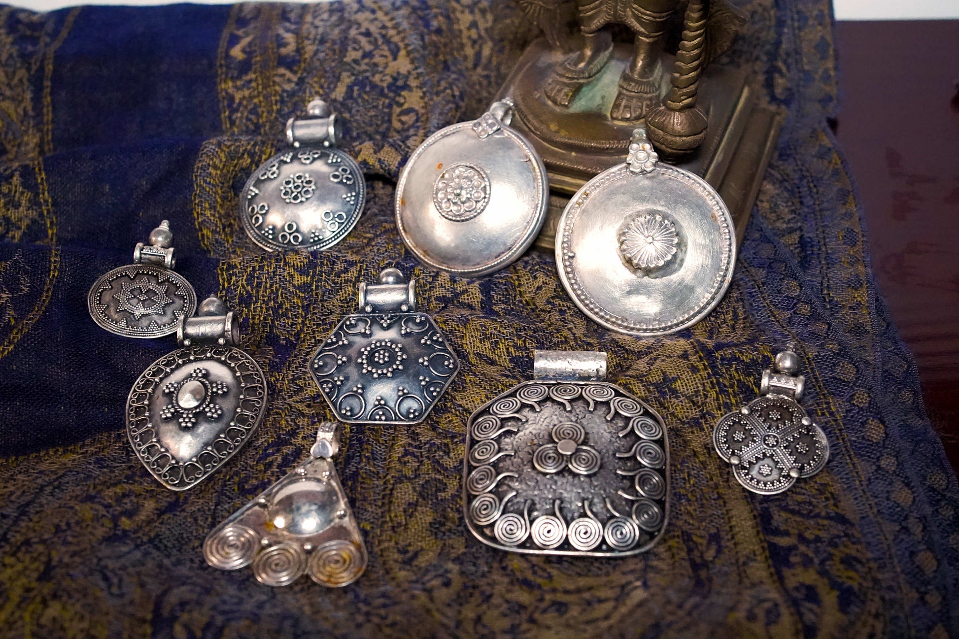 Vista d'insieme della collezione di pendagli artigianali indiani in argento 925.