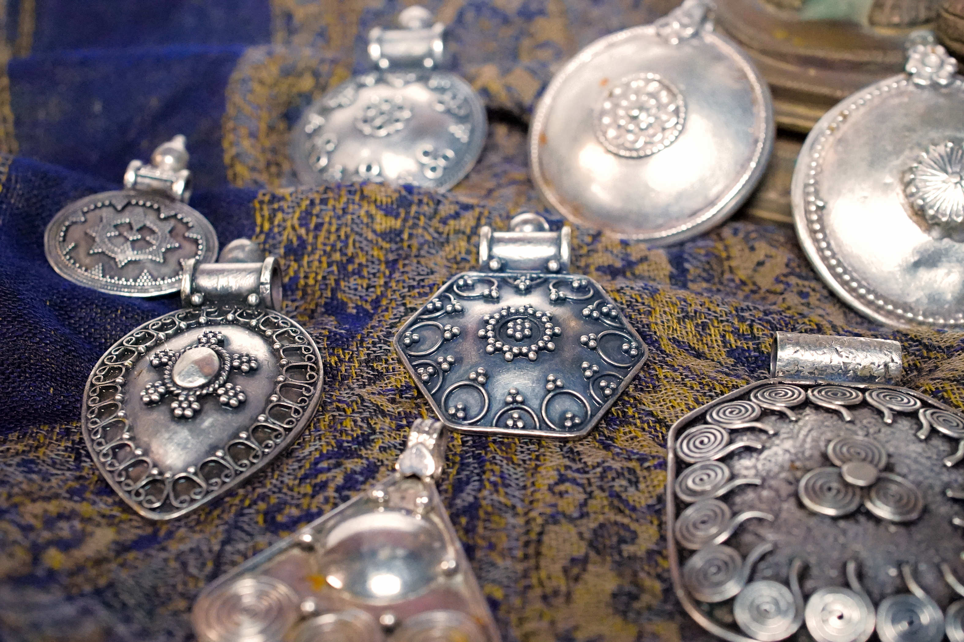 Vista d'insieme della collezione di pendagli artigianali indiani in argento 925.