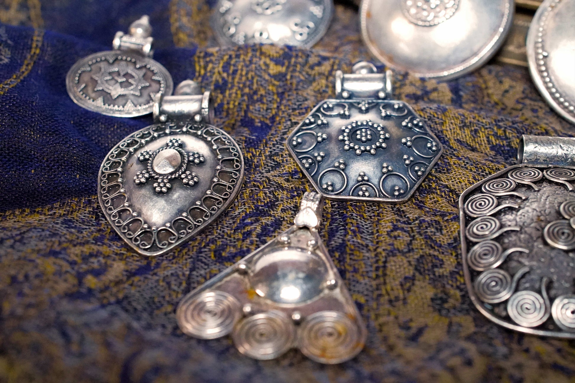 Vista d'insieme della collezione di pendagli artigianali indiani in argento 925.
