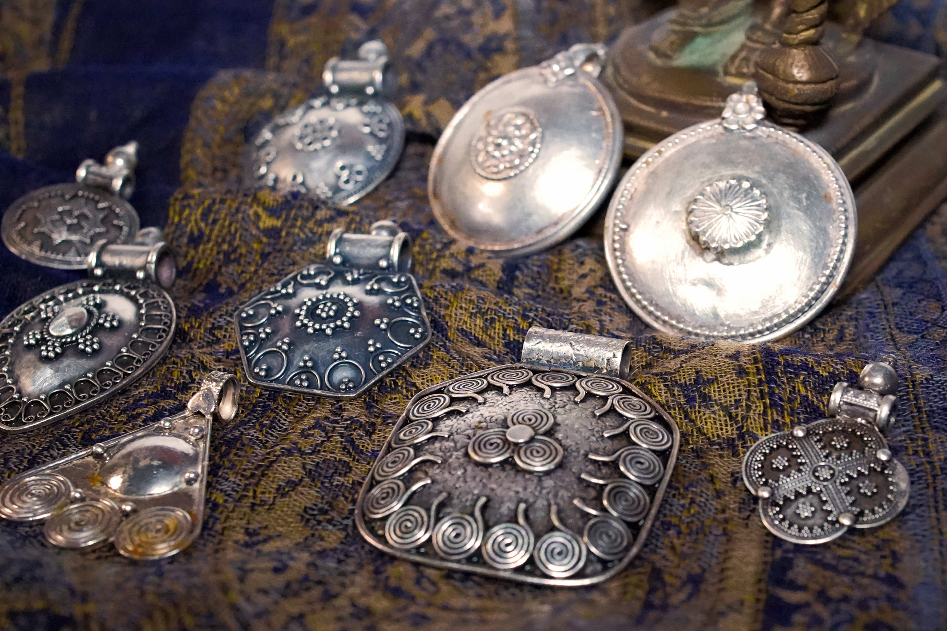 Vista d'insieme della collezione di pendagli artigianali indiani in argento 925.